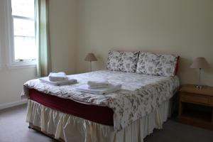 ロッホゴイルヘッドにあるCarrick Farm Lochside Appartment (GF)のベッドルーム1室(ベッド1台、タオル2枚付)
