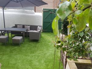 a patio with a table and chairs and an umbrella at Llandudno holiday home in Llandudno