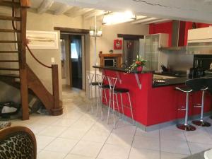 une cuisine avec un comptoir rouge et des tabourets dans l'établissement Maison entière avec cour dans le Chablisien, à Villy