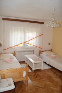 a room with two beds and a table in it at Apartment Drago in Rakovica