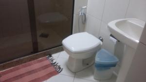 y baño con aseo, lavabo y ducha. en Clube Praiano, en Cabo Frío