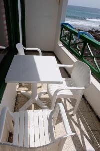 アリエタにあるSEA & RELAX - Apartament 1 Izqの白いテーブルとビーチ付きのバルコニー(椅子2脚付)