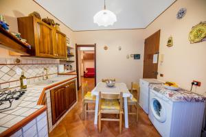 a kitchen with a table and a washing machine at Casa Mimí in Cefalù