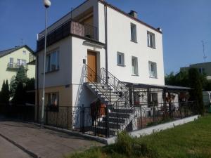 a white building with stairs on the side of it at OLEŃKA in Darlowko