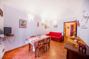 a living room with a table and a red couch at Casa Mimí in Cefalù