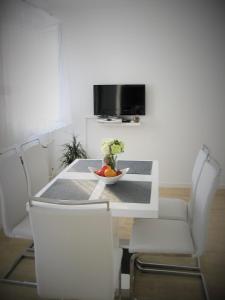 - une table à manger et des chaises avec une corbeille de fruits dans l'établissement Apartment Nizic, à Primošten