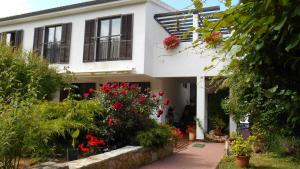 a white house with red flowers in front of it at ZARA APARTMENT in Banjole