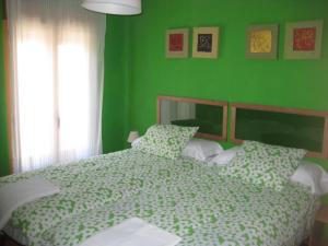 Casa La Alegria De La Alcarria II في سيغوينزا: غرفة نوم خضراء بسرير وجدار أخضر