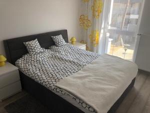 a bed in a bedroom with a large window at Apartament Jula 2 in Pogorzelica