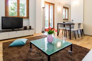 una sala de estar con un jarrón de flores sobre una mesa en Stylish JOIVY Flat with Garden, en Pognana Lario