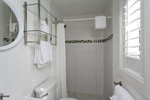 a white bathroom with a toilet and a mirror at Inn on the Beach in St. Pete Beach