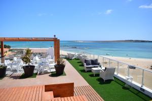 uma varanda com mesas e cadeiras na praia em Ouril Hotel Agueda em Sal Rei