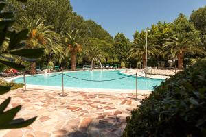 una gran piscina con palmeras en un parque en Seebay Hotel, en Portonovo