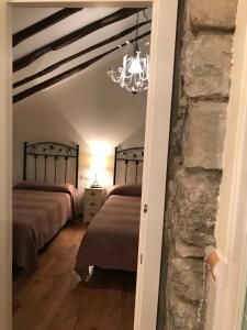 a bedroom with two beds and a stone wall at Casa Campo in Abay