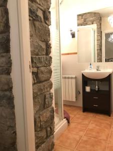 a bathroom with a stone wall and a sink at Casa Campo in Abay