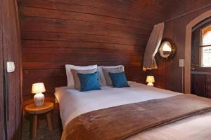 a bedroom with a large bed with blue pillows at Hotel De Vrouwe van Stavoren in Stavoren