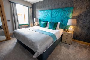 a bedroom with a large bed and a large window at Heathmount Hotel in Inverness