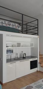a kitchen with white cabinets and white appliances at Tempo Life Apartman in Budapest