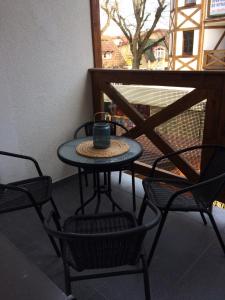 a table and chairs on a balcony with a drink on it at Ekspresja in Rowy