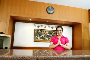 una mujer sentada en un mostrador delante de una pared en Chaidee Mansion, en Bangkok 39 fotos más