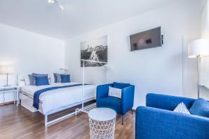 ein Schlafzimmer mit einem Bett und zwei blauen Stühlen in der Unterkunft Studio Lux city in Luxemburg (Stadt)