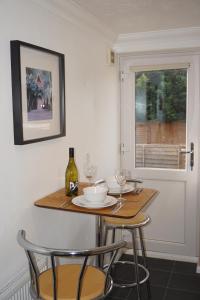 a table with two chairs and a bottle of wine at Holt Apartment in Bristol