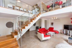 a living room with red chairs and a staircase at Your Villa Algarve Private pool 5 min walk to beach in Burgau