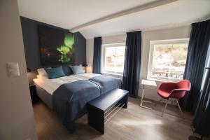 a bedroom with a bed and a red chair at Koppangen Brygger in Koppangen