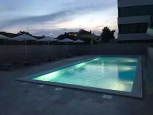 basen z leżakami i parasolami w budynku w obiekcie Luxury Apartment Kortina w mieście Zadar