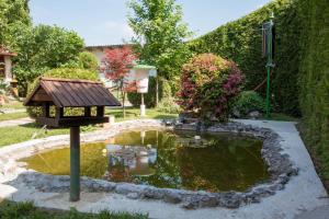 a small pond with a bird feeder in a garden at Sobe Dario in Daruvar
