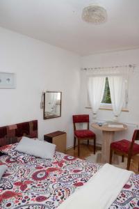 a bedroom with two beds and a table and chairs at Sobe Dario in Daruvar