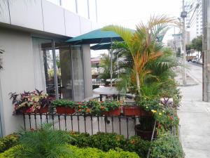 un ristorante con fiori e piante di fronte a un edificio di HM International Hotel a Guayaquil