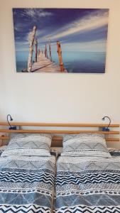 een schilderij van een pier aan de muur boven een bed bij Apartment Balaton in Siófok