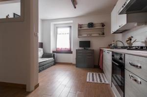 uma cozinha com um lavatório e um fogão em Casa Dantina Stenico em Stenico