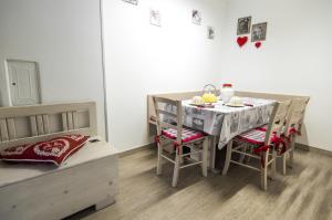 uma sala de jantar com uma mesa e cadeiras e uma cama em Casa Dantina Stenico em Stenico