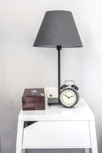 una lámpara y un reloj despertador sobre una mesa blanca en Athens 8 min from Acropolis, en Atenas
