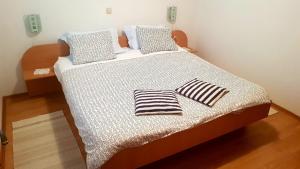 a bed with two pillows on it in a room at Apartments Zvono in Slano