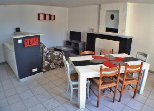een keuken met een tafel en stoelen in een kamer bij Le calme de la campagne à 10 minutes des plages in Arvert