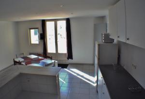 een keuken met een tafel en een koelkast in een kamer bij Le calme de la campagne à 10 minutes des plages in Arvert