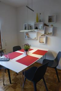キールにあるFerienwohnung Kielのダイニングルームテーブル(黒い椅子、赤と白のラグ付)
