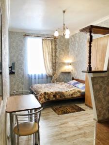 - une chambre avec un lit, une table et une chaise dans l'établissement Apartments near Rynok Square, à Lviv