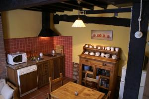 a kitchen with a sink and a table with a microwave at La Cuestecilla in Hervás