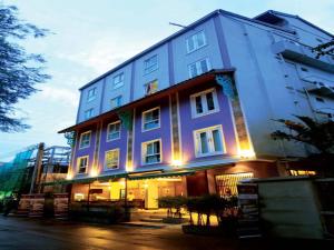 een groot blauw gebouw met verlichting bij Sawasdee Hotel @ Sukhumvit Soi 8 in Bangkok