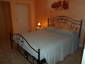 een slaapkamer met een bed met een wit dekbed bij Villa Martina nel Salento in Tiggiano