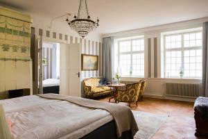 a bedroom with a bed and a chandelier at Hotell Breda Blick in Visby +120 photos