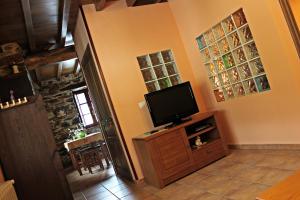 a living room with a flat screen tv on a cabinet at Apartamentos El Llago in Boal