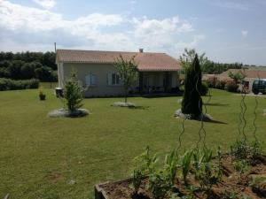 a house with a grass yard with a house at Brigitte room in Barro