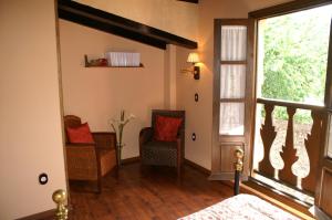 エルバスにあるLa Cuestecillaの椅子2脚と窓が備わる客室です。