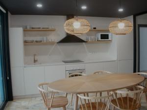 a kitchen with a wooden table and chairs at Apartamento Lapamán in Bueu