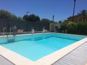 een zwembad met blauw water voor een hek bij Villetta San Leone in Agrigento